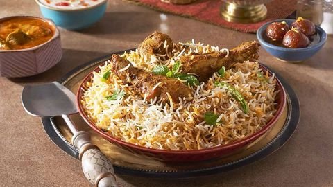 Chicken biryani platter with curry, raita and gulab jamun