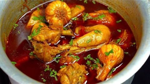 Chicken handi simmering in a deep pot with fresh coriander